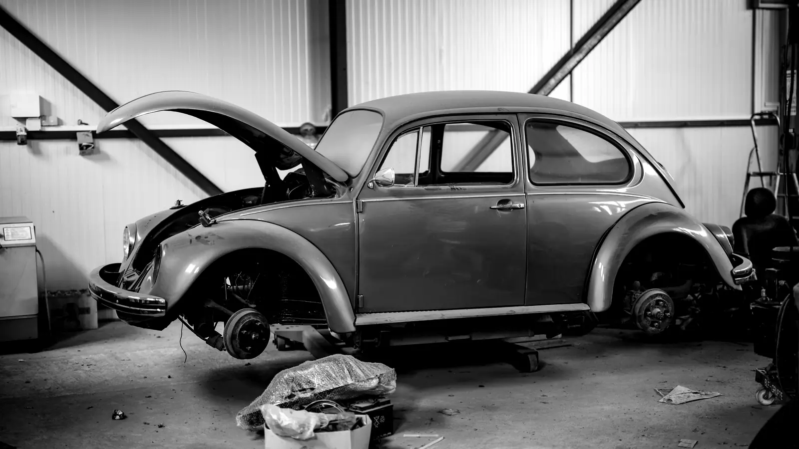 Klassieke auto in de werkplaats, deels gedemonteerd tijdens onderhoud.